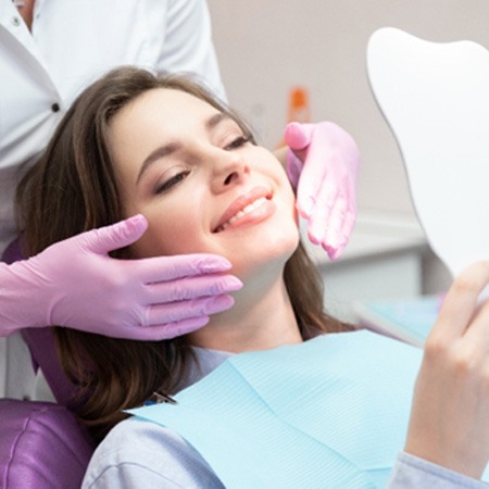 A woman admiring the results of cosmetic dentistry