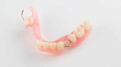 Full upper and lower dentures against dark background