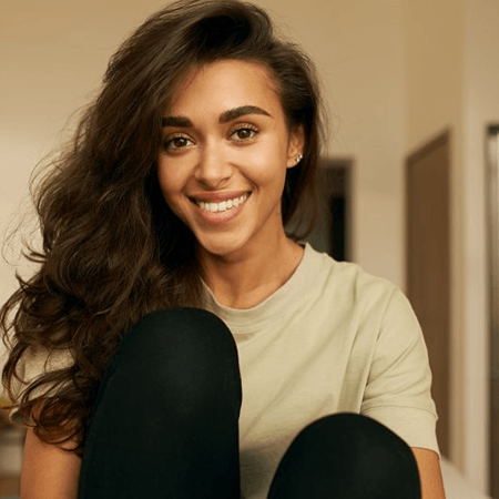 a woman smiling with straighter teeth after undergoing Invisalign