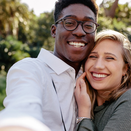 Couple smiling while hugging outside