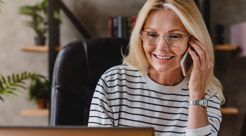 Woman with glasses smiling while talking on phone
