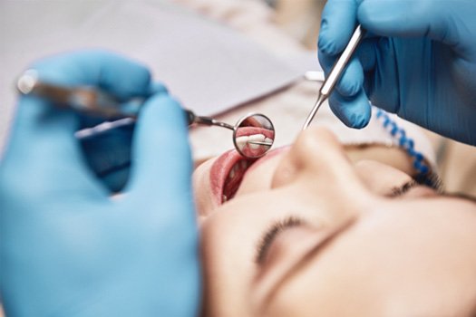 Closeup of patient’s teeth reflected in dental mirror during exam