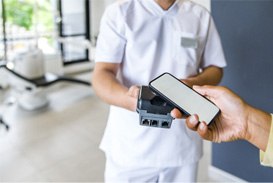 A patient using their smart phone to pay the cost of veneers