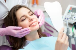 Woman smiling while looking at her veneers treatment results